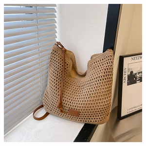 Detailed close-up of beige woven mesh bag featuring premium brown leather shoulder straps