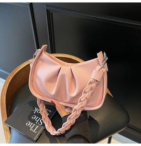 Close-up of pink ruched cloud bag with distinctive chunky braided strap and silver metal hooks