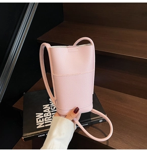 Close-up of pink pebbled leather crossbody phone bag with minimalist texture detail