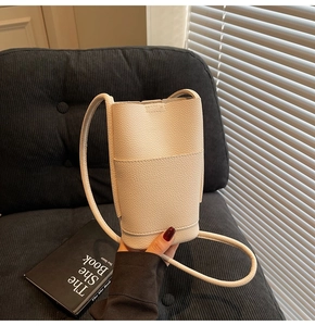 Detail of off-white lychee grain leather crossbody phone bag with slim shoulder strap