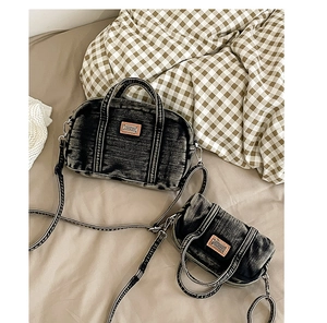 Détail d'un ensemble cabas en denim gris avec mini pochette et écusson en cuir