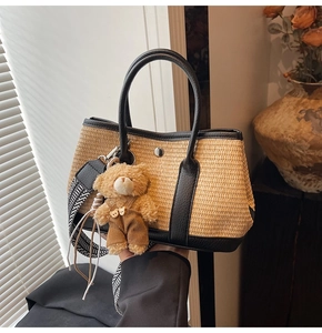 Détail du sac cabas en paille avec lanières en cuir noir et bandoulière tissée géométrique