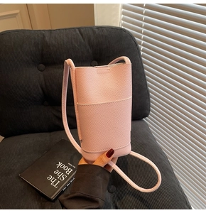 Close-up of pink lychee textured crossbody phone bag held by hand for daily use