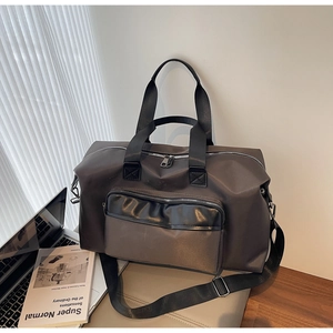 Detail of dark brown travel bag with zipper pocket and adjustable shoulder strap