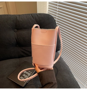 Detailed view of pink lychee leather crossbody phone bag with slim shoulder strap