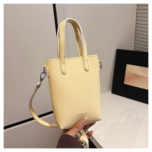 Détail du mini sac jaune clair montrant le grain de litchi et les ferrures argentées