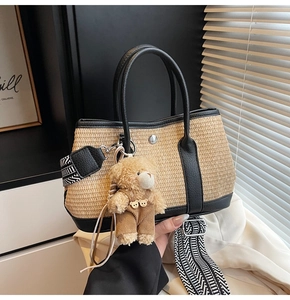 Détail du sac à main en paille tressée avec bordure en cuir et bandoulière géométrique