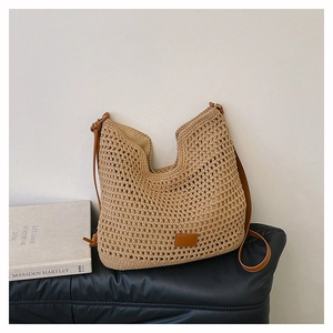 Detail of hollow woven texture on beige crochet tote bag with brown leather accents