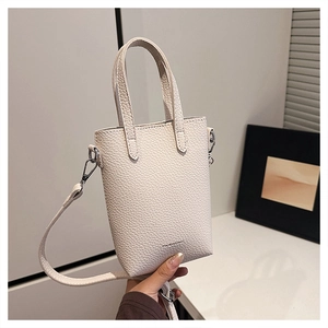 Gros plan détaillé sur le cuir grainé beige clair avec des ferrures argentées mode