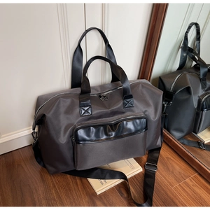 Close-up of a large dark grey travel duffel bag on wood floor for fitness and sports