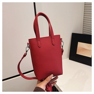 Détail du petit sac cabas en cuir rouge avec bandoulière amovible et réglable