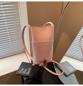 Close-up of pink litchi grain leather mini phone crossbody bag with slim strap details