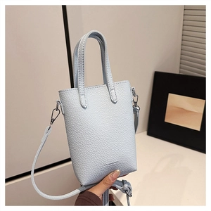 Détail du mini sac cabas bleu clair avec texture grainée et inscription FASHION