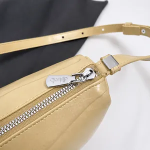 Close-up of premium metal zipper and pebble leather texture on minimalist handbag