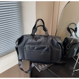 Close-up of waterproof black travel bag with dual handles and smooth nylon texture