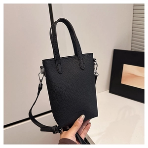Détail du mini sac noir en cuir grainé avec crochets métalliques et inscription FASHION