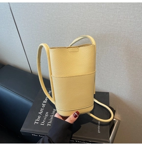 Detail of yellow lychee grain leather mini crossbody bag with front slip pocket
