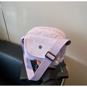 Details der violetten Nylon-Umhängetasche mit Faltenstruktur und mehreren Reißverschlussfächern