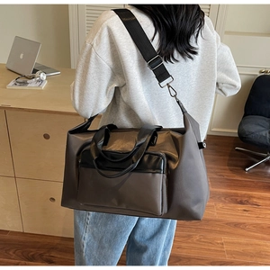 Detail showing high-capacity travel bag with adjustable strap worn over shoulder