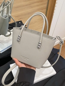 Grey pebbled leather bucket bag with silver bead accents and detachable shoulder strap