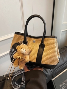 Sac seau en paille contrastée avec bordure en cuir noir, bandoulière large et ours