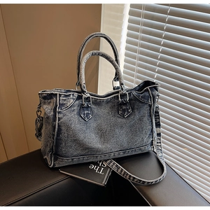 Détail d'un sac cabas en denim vintage avec rivets rétro et doubles poignées
