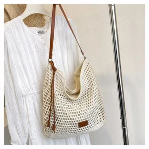 Detailed view of cream woven shoulder bag with brown leather straps and summer linen dress