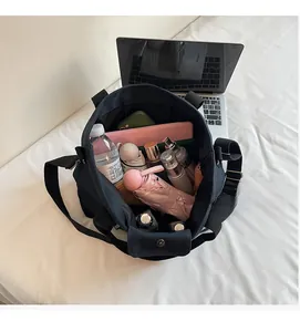 Interior view of large capacity black canvas tote bag holding a laptop and daily essentials