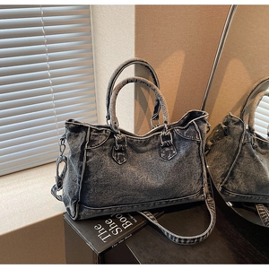 Détails du sac cabas en jean délavé vintage avec ornements style motard et coutures rétro