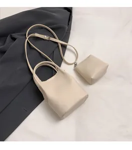 Detail of off-white lychee grain leather bucket bag with matching inner zipper pouch