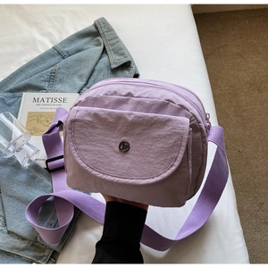 Details der lila Nylon-Umhängetasche mit verstellbarem Gurt und Reißverschluss