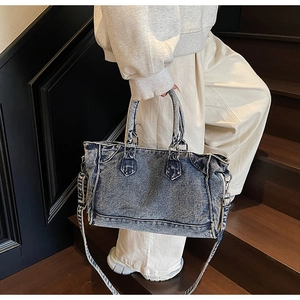 Détail du sac cabas en jean délavé vintage avec coutures apparentes et bandoulière réglable