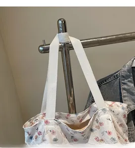 Detailed view of the white floral canvas bag showing the thick webbed long shoulder strap