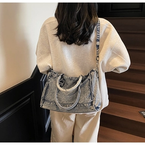 Gros plan du sac cabas en denim vintage avec doubles poignées et bandoulière réglable