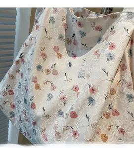 Close-up of floral tote bag fabric with intricate lace textures and colorful flower patterns
