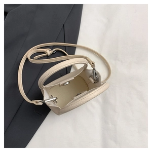 Detail of cream bucket bag showing lychee grain leather, interior and silver magnetic buckle