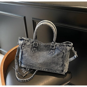 Détail du sac cabas vintage en denim bleu sur une chaise en bois avec bandoulière