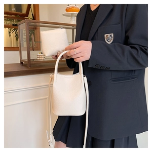 Detailed shot of a white litchi pattern bucket bag with small coin purse and strap
