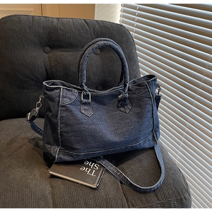 Détail du sac cabas vintage en jean avec surpiqûres blanches et ferrures argentées