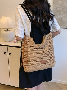 Handmade khaki woven tote bag for summer beach travel with leather drawstring detail