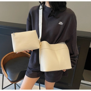 Detail of cream white lychee texture bucket bag and small pouch on modern lifestyle model