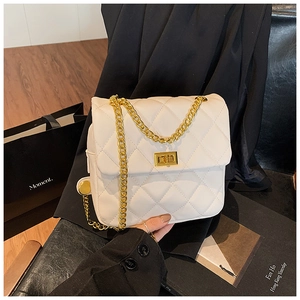 Detailed view of white quilted PU leather bag with golden twist lock and chain strap