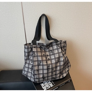 Detail of canvas tote bag featuring black and white grid pattern with cartoon bear prints
