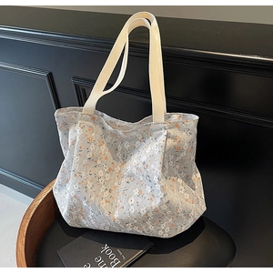 Dettagli della borsa tote in pizzo bianco con stampa floreale arancione su sfondo nero