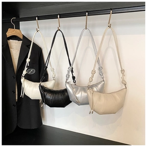 Detailed display of crescent bags in four colors with knotted straps on a display rack