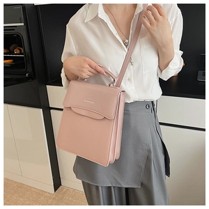 Detail of light pink leather handbag with silver Fashion & Bag lettering and top handle