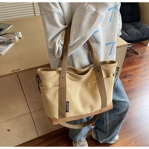 Detail of a large canvas tote bag with contrast stitching and adjustable strap