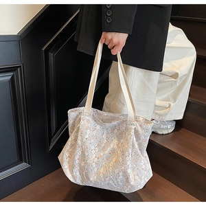 Close-up of a floral lace tote bag for women showing fine mesh details and summer patterns