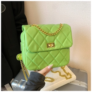Close-up of vibrant green quilted crossbody bag featuring a gold chain strap and square twist lock