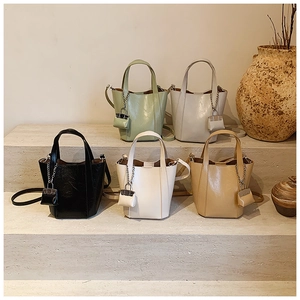 Detailed display of five stylish bucket bags in sage green, grey, black, cream, and tan